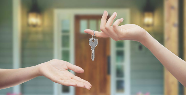 person handing someone keys to a new house