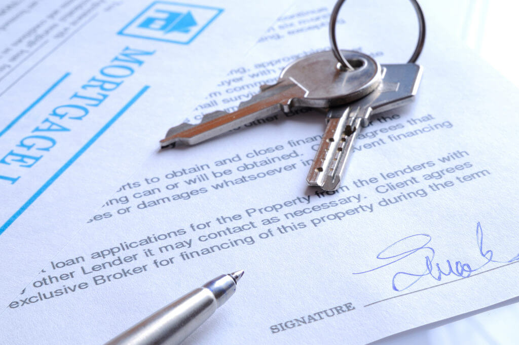 mortgage contract signed with detail of keys to buying a home closeup